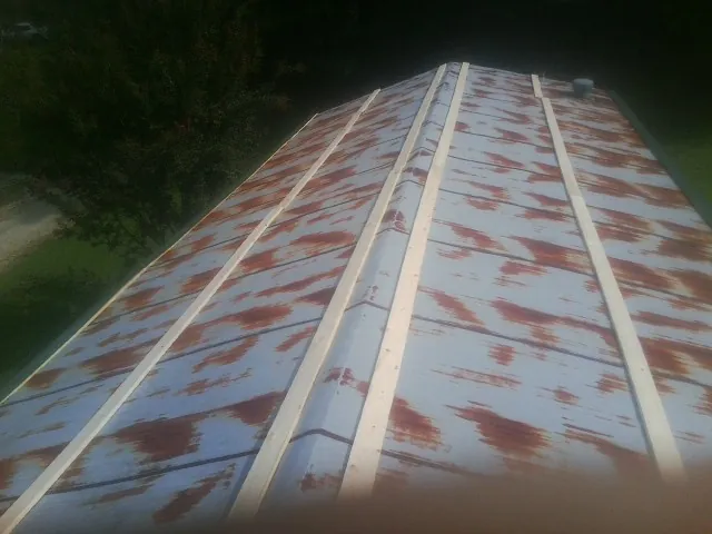 Rusted metal roof panels with new wood purlins before replacement — Storm Damage Roof Repair in Havana by Roofing Brothers